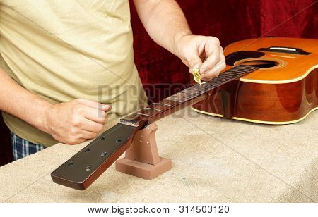 Musical Instrument Guitar Repair And Service - Worker Moistening And Impregnation Of An Fingerboard 