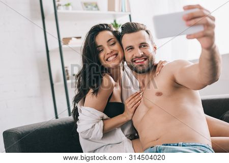 Handsome Man And Sexy Woman In Shirt And Bra Smiling And Taking Selfie