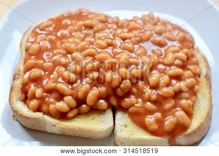 Baked Beans In Tomato Sauce On Thick White Toast Served On A White Plate