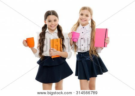 Taking A Few Minutes Break From Their Books. Little Schoolgirls Having Tea With Milk For Break. Smal