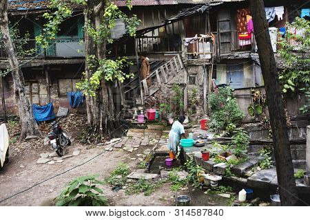 Pune, India, July 2012, Woman Washing Utensils At Old Building In Wadas.