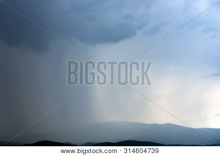 The Rain From The Clouds Gradually Covers The Mountains.
