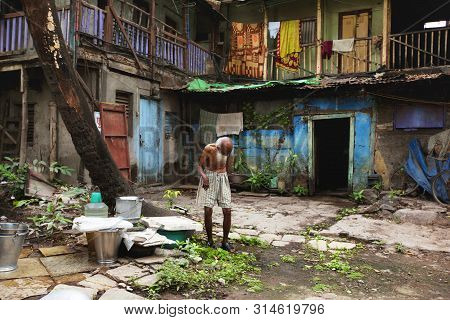 Pune, India, July 2012, Old Man Walking Outside Old Building In Wadas
