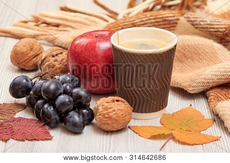 Grapes, Walnuts, Apple, Cup Of Coffee, Checkered Plaid And Dry Leaves On Wooden Boards. An Autumn St