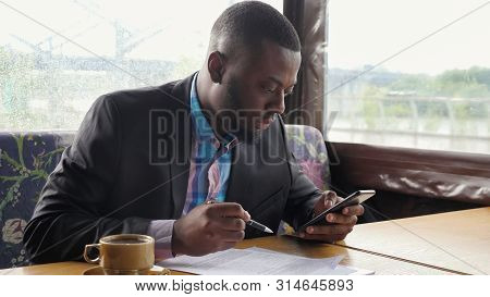 Black Guy Is Making Paperwork. Afro American Businessman Is Filling Documets In Summer Tent Cafe Loo