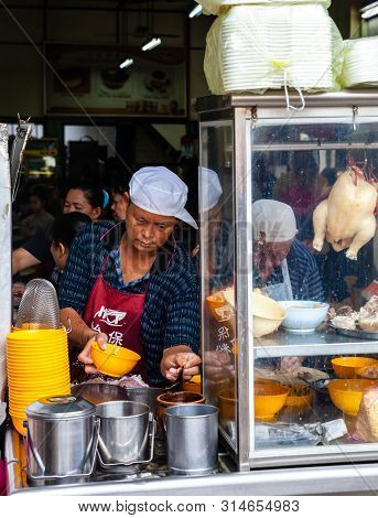 Ipoh, Malaysia - December 11: Man Serves Up Chicken Soup For Clients On A Food Court Of Ipoh On Dece