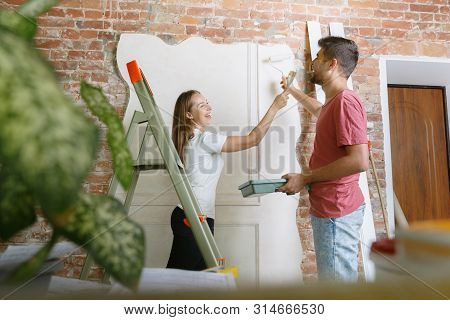 Young Couple Doing Apartment Repair Together Themselves. Married Man And Woman Doing Home Makeover O