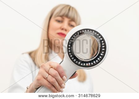 The Doctor Trichologist Dermatologist Examines The Camera Through The Dermatoscope.