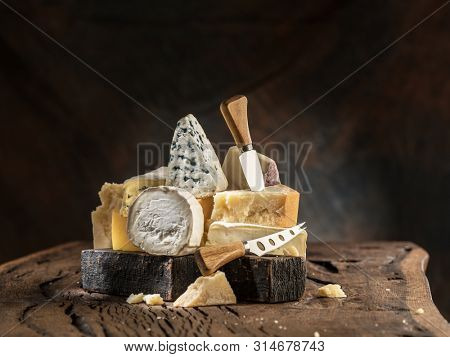 Assortment of different cheese types on wooden background. Cheese background.