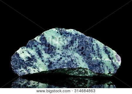 Raw Blue Zoisite Or Saualpite Mineral Stone In Front Of Black Background, Mineralogy And Esotericism