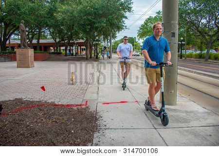 Tampa Bay, Florida. July 12, 2019  People Enjoying Shared Electric Scooter In Centennial Park At Ybo