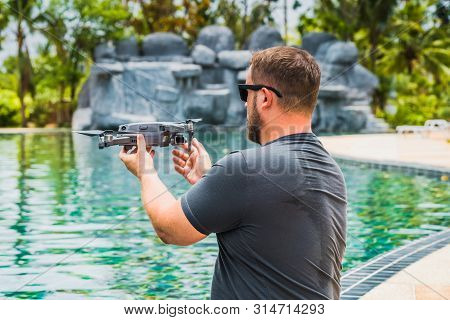 A Sympathetic Man Launches A Drone For Flight, With Which You Can Take Photos And Videos, Near The S