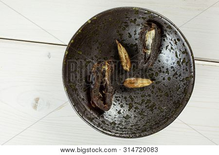Group Of Two Halves Two Pieces Of Dried Brown Date Medjool On Grey Ceramic Plate Flatlay On White Wo