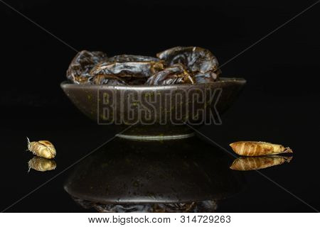 Group Of Lot Of Whole Two Pieces Of Dried Brown Date Medjool On Grey Ceramic Plate Isolated On Black