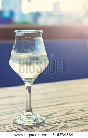 A Glass Of Cold White Wine On The Table On The Terrace Of A Summer Cafe