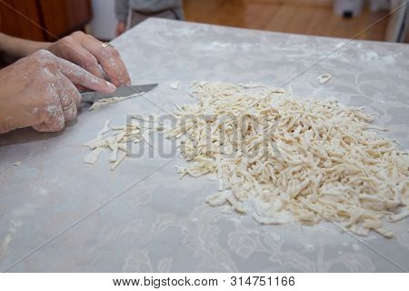 Cutting Long Dough Stripe For Cooking Pasta. Homemade Food Preparation Concept. Closeup Of Process O