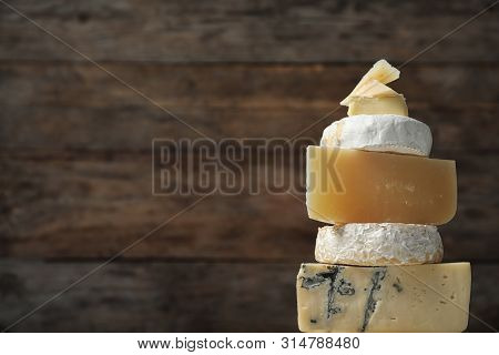 Different Types Of Delicious Cheese Against Wooden Background, Closeup. Space For Text