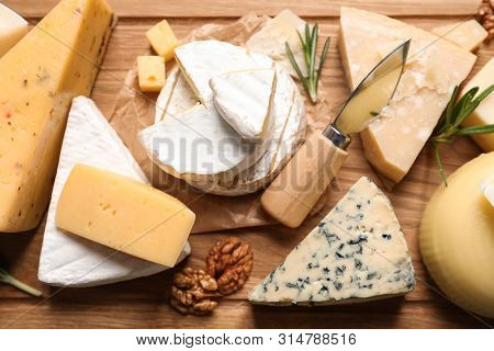 Different Delicious Cheeses Served On Wooden Board, Above View