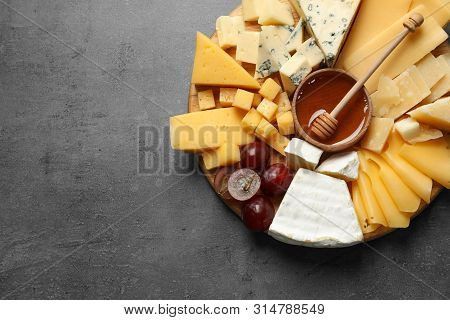 Different Types Of Delicious Cheese And Snacks On Served Grey Table, Top View. Space For Text