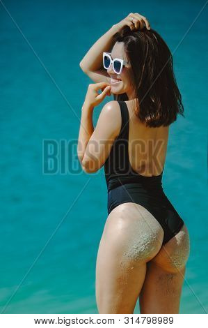 Woman In Black Swimsuit At Sand Beach View From Behind Summer Vacation