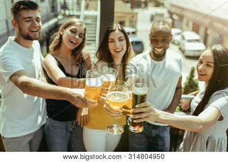 Young Group Of Friends Drinking Beer, Having Fun, Laughting And Celebrating Together. Women And Men 