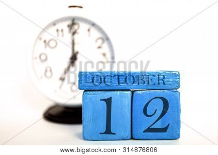 October 12th. Day 12 Of Month, Handmade Wood Calendar And Alarm Clock On Blue Color. Autumn Month, D
