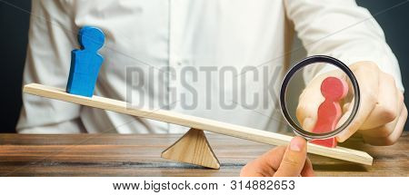 The Family Lawyer Shares The Figure Of A Man And A Woman On Scales. The Concept Of Divorce And Divis