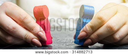 Woman Holds Wooden Figures Of A Man And A Woman. Family Relationships And Problem Solving. Psycholog