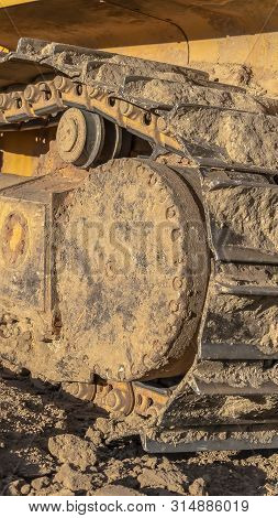 Vertical Frame Yellow Excavator With Close Up View Of The Grouser Pad Track Frame And Rollers