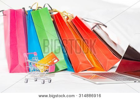 Shopping Bags, Credit Card In Trolley And Computer. Online Shopping Or E-commmerce Concept.