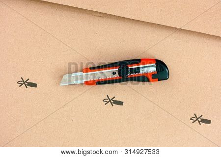 Paper Knife On Cardboard With Do Not Open With Knife Sign. Closeup.