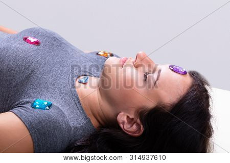 Photo Of Young Woman Undergoing Hypnotherapy With Stones