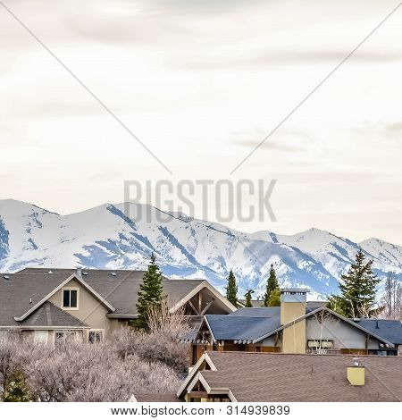 Square Frame Neighborhood In Winter With Snow Covered Mountain And Overcast Sky Background