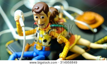 Songkhla, Thailand - November 24, 2018: Woody Listen To Music Girl.this Figure By Disney Pixar Inc.