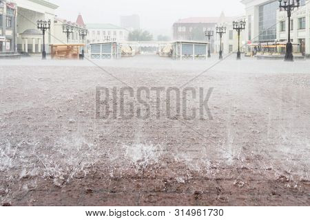 Heavy Rain In The City. Close Up Sidewalk With Brown Rectangle Tiles Under Water With Big Raindrops.