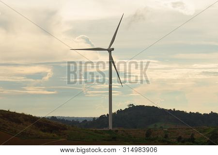 Wind Turbine Silhouette On The Mountain At Sunset, Renewable Energy.
