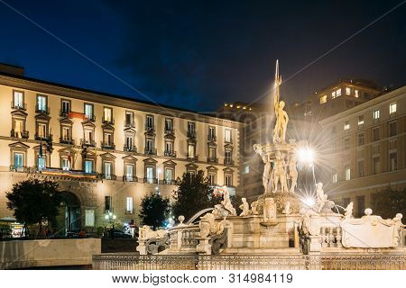 Naples, Italy. Fountain Of Neptune On Piazza Municipio In Evening Or Night Illuminations.