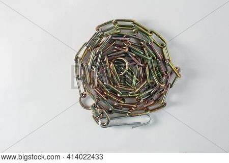 Yellow Iron Dog Chain Rolled Around In A Circle On A White Background. View From Above