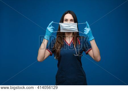 Doctor With Aseptic Mask In Hands In Front Of Her Face.