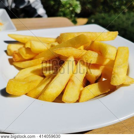 Fast Food French Fries On Summer Terrace Or Cafein A White Plate.
