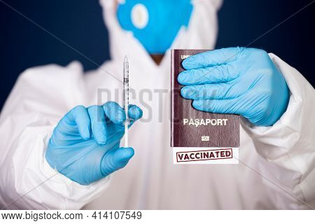 Doctor holding passport with VACCINATED sign and vaccine. Immunity passport, risk-free certificate concept.