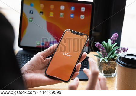Chiang Mai, Thailand - Mar 08, 2021 Woman Using Payoneer On Iphone With Tablet On Background. Payone
