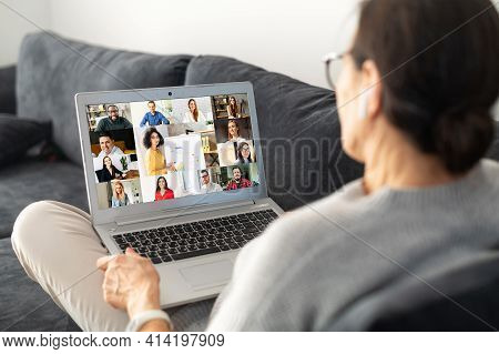 Contemporary Senior Woman Lying On The Comfortable Sofa And Using Laptop For Video Connection With G