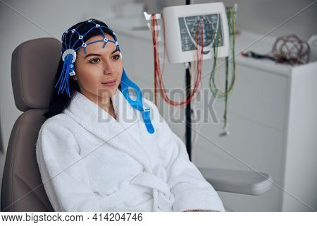 Pensive Calm Woman Sitting In The Chair Before The Electroencephalography