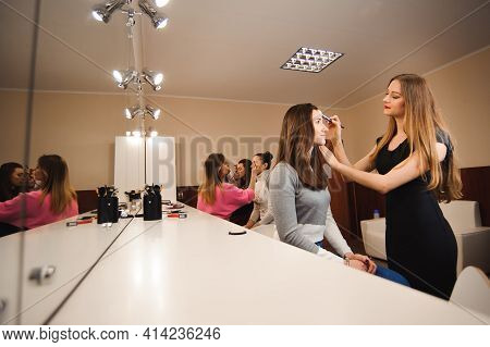 Make Up Artist Doing Professional Make Up Of Young Woman. Beauty Shcool.