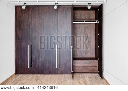 Open Doors Of Wardrobe With Inner Drawer Made Of Dark Oak In Room