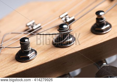 Guitar Fretboard With Tuning Pegs And Strings On A Gray Background. Close-up
