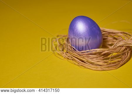 Pearl Colored Egg In The Nest On A Yellow Background. Easter Concept.