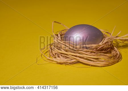 Pearl Colored Egg In The Nest On A Yellow Background. Easter Concept.