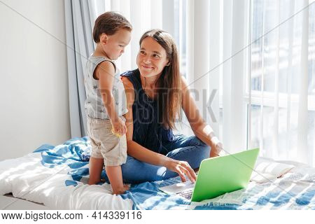Work From Home With Kids. Mother Working On Laptop With Baby Boy Toddler At Home. Remote Work, Dista